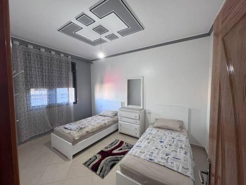 une chambre avec deux lits, une commode et un miroir dans l'établissement Apartment in Houceima, Ajdir, à Ajdir