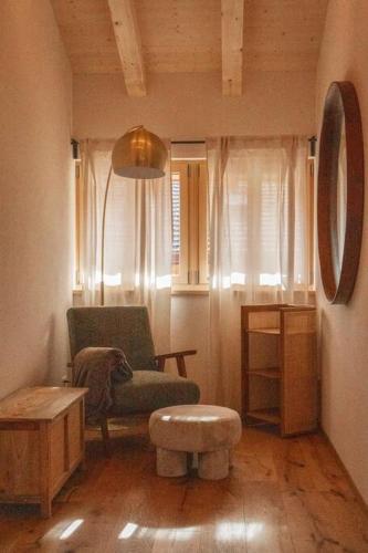 a living room with a chair and a stool at Hidden Retreats The MountainHut in Wengi bei Frutigen