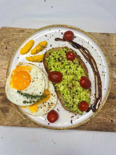a plate of eggs and toast with tomatoes and fruit at B&B Iets Zeeuws in Kats