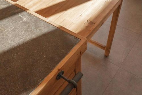 a wooden table with a black counter top at Hidden Retreats The MountainHut in Wengi bei Frutigen