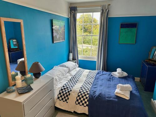 a blue bedroom with a bed and a window at 3BD Victorian Townhouse Near Norfolk Broads 4A, 2C in Beccles