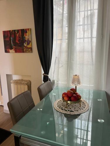 a glass table with a bowl of fruit on it at Casa Emma in Porto Ceresio