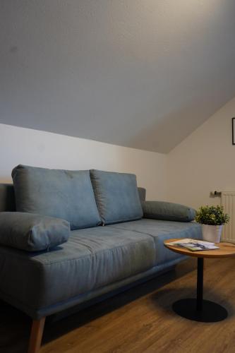 a blue couch in a living room with a table at Bucheggerhof in Schladming
