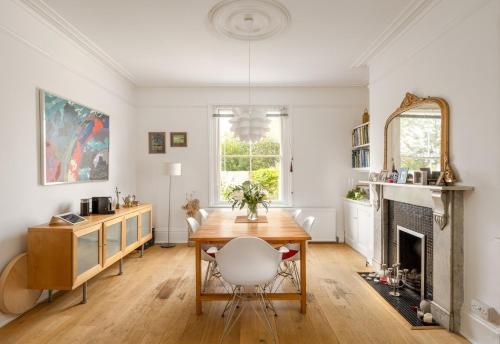 a dining room with a table and a fireplace at 3BD Victorian Townhouse Near Norfolk Broads 4A, 2C in Beccles