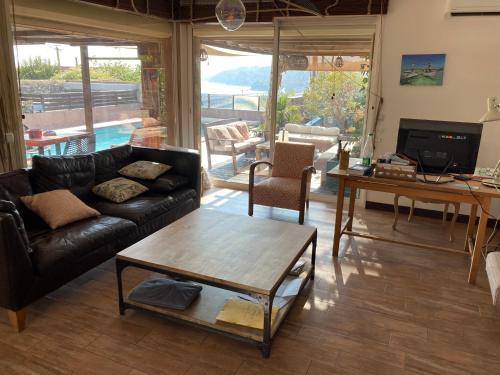 un salon avec un canapé et une table dans l'établissement Maison vue sur mer avec Piscine - Estaque - Côte Bleue, à Marseille