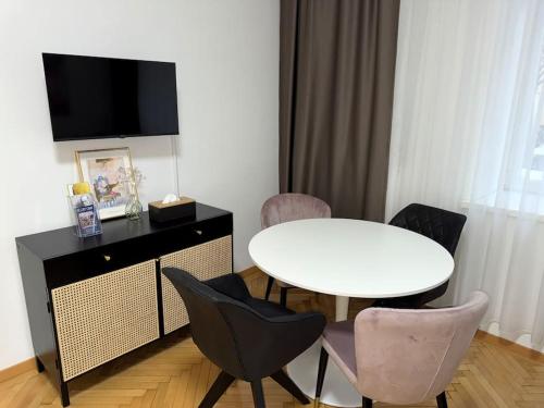 una sala da pranzo con tavolo e sedie bianchi di Neu! City Apartment im Stadtzentrum 4 a Vienna