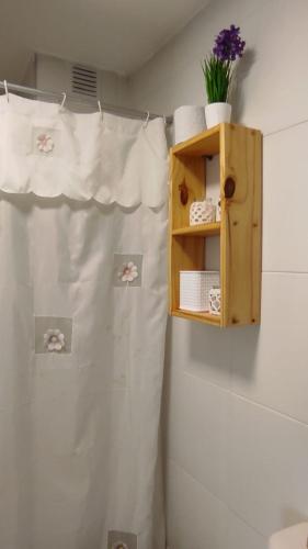 een badkamer met een wit douchegordijn en een plankje bij SILVESTRE - Departamento in Cordoba