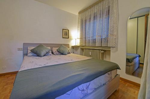 Un dormitorio con una cama grande con ventana. en Dulci du Mont Blanc, en Courmayeur
