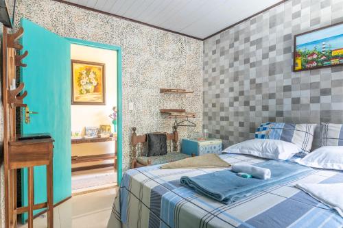 a bedroom with a bed and a tv on a wall at Pousada Flor de Olinda in Olinda