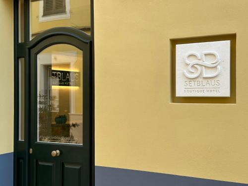 a door with a sign on the side of a building at SetBlaus Boutique Hotel in Ciutadella