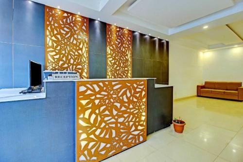 a lobby with a wall with a wooden pattern on it at Hotel O Meridian Grand in Shamshabad