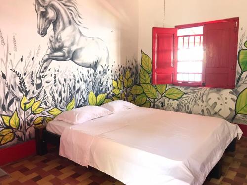 a bedroom with a painting of a horse on the wall at Hacienda Santa Isabel in Fredonia