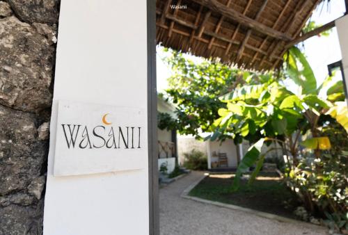 a sign that reads wasanu on the side of a building at Artists' Guesthouse Sleep&Dream - Zanzibar in Zanzibar City