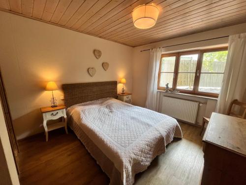 ein Schlafzimmer mit einem Bett, zwei Tischen und zwei Lampen in der Unterkunft Chiemsee Beachhouse Apartment in Bernau am Chiemsee