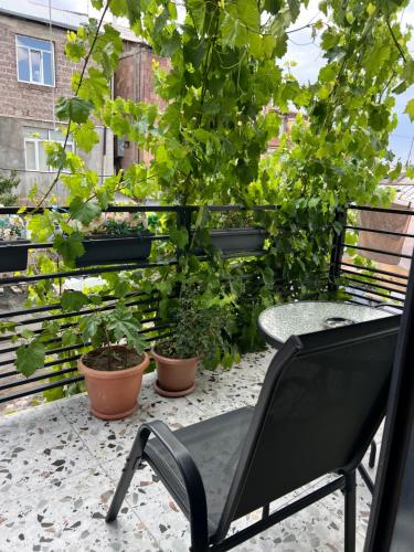 a black chair sitting on a balcony with plants at STATION BOUTIQUE HOTEL in Gyumri