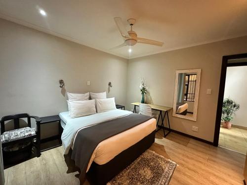Un dormitorio con una cama y un ventilador de techo. en The Hide D on Devereux, en East London
