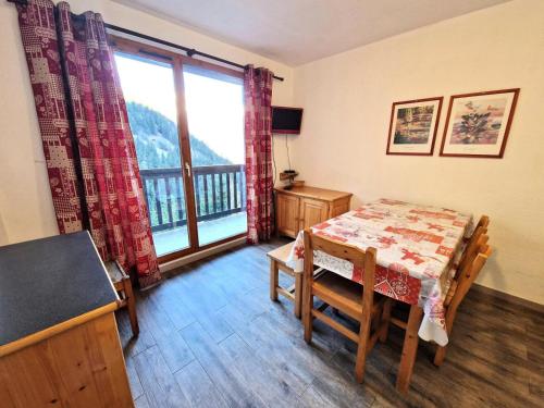 une salle à manger avec une table et une grande fenêtre dans l'établissement Résidence Grand Argentier - 2 pièces +cabine 4/6 personnes coeur station 32m² MAE-2922, à Modane
