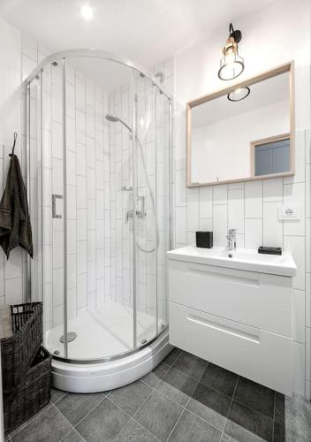 a white bathroom with a shower and a sink at Sunshine apartamentai in Alytus