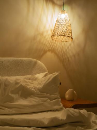 a bedroom with a bed with a pillow and a lamp at Taga Suites in Catania