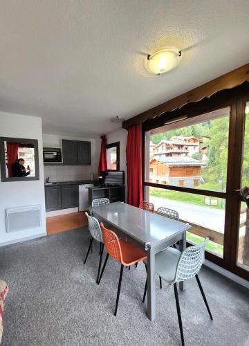un salon avec une table et des chaises et une cuisine dans l'établissement Résidence Les Balcons De La Vanoise - LES BALCONS DE LA VANOISE - BV406 MAE-3186, à Villarodin-Bourget