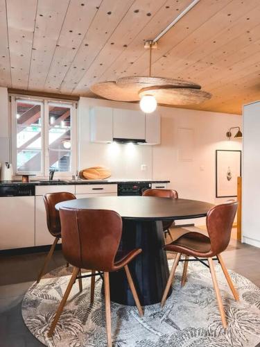a kitchen with a table and chairs in a room at Hidden Retreats The Seehof 2 in Oberhofen am Thunersee