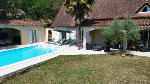 une maison avec une piscine dans une cour dans l'établissement Maison des soles piscine Cahors St Cirq Lapopie, à Lamagdelame