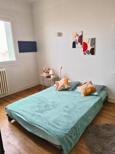 une chambre avec un lit avec une couette bleue dans l'établissement Chambre Cosy proche de la gare, à Toulouse