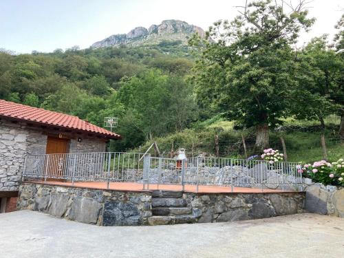 a house with a fence and a stone wall at FUENTE OSCURA in Ramales de la Victoria