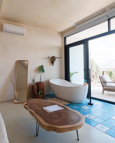 a bathroom with a large tub and a table at Native Residence in Rosarito