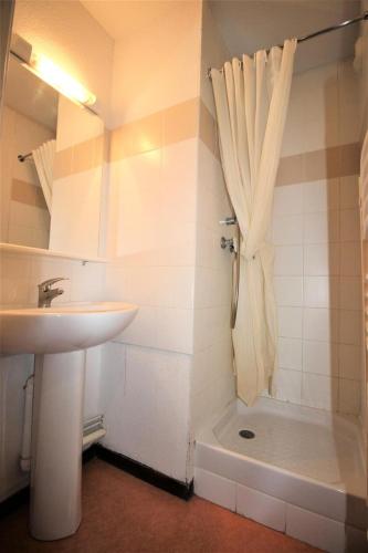 La salle de bains est pourvue d'un lavabo et d'une douche avec rideau. dans l'établissement Résidence Les Balcons De La Vanoise - LES BALCONS DE LA VANOISE - BV517 MAE-4613, à Villarodin-Bourget