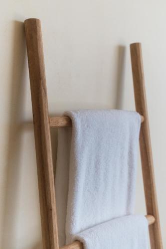 a wooden chair with a white towel on it at Native Residence in Rosarito