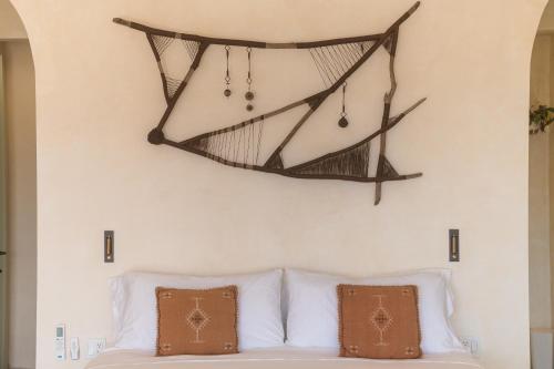 a hammock hanging above a bed with pillows at Native Residence in Rosarito
