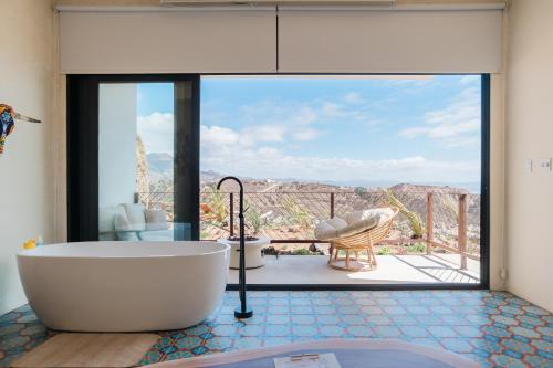 a bath tub in a bathroom with a view at Native Residence in Rosarito