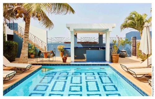 a swimming pool with chairs and a palm tree at Senebreizh in Somone