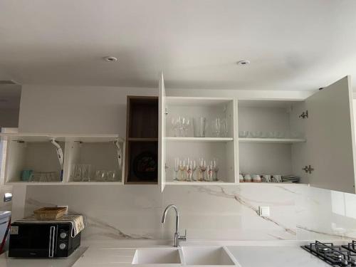 kuchnia z białymi szafkami i zlewem w obiekcie Dreams Flat w mieście Tunis