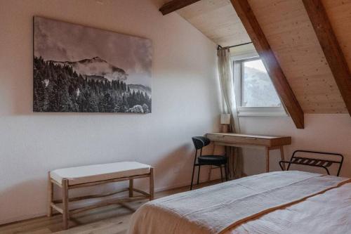 a bedroom with a bed and a desk and a window at Hidden Retreats The GlacierDoor in Frutigen