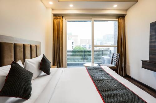 a hotel room with a bed and a large window at Super Townhouse MA-32 in Gurgaon