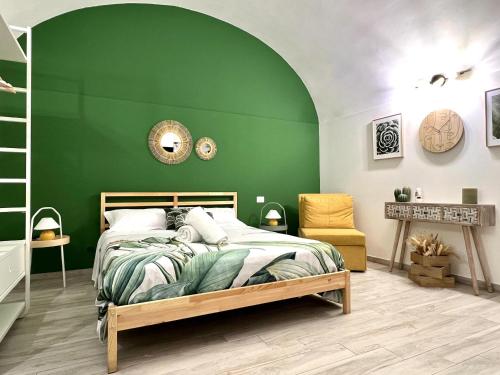 una camera da letto verde con un letto e una parete verde di Borghetto Capuana House a Catania