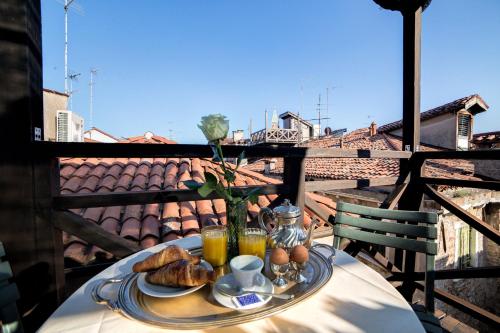ein Tisch mit einem Teller Essen auf einem Balkon in der Unterkunft Lanterna Di Marco Polo in Venedig