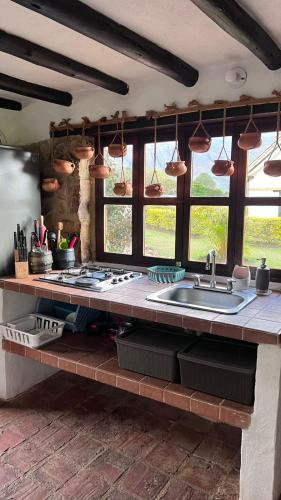 a kitchen with a counter with a sink and windows at Hotel, Glampings y Cabaña Magic Bungalow in Villa de Leyva