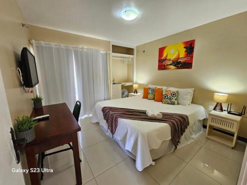 a bedroom with a bed and a desk and a television at FRENTE MAR - Cumbuco - Eco Paradise in Cumbuco