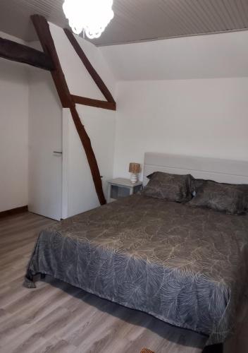 une chambre avec un lit et un parquet dans l'établissement La ferme des aristochats, à Blicourt