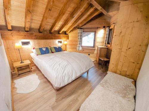 - une chambre avec un grand lit dans une cabane en bois dans l'établissement Chalet Des Encombres - Chalet au centre de St Martin de Belleville, proche du téléski MAE-4314, à Saint-Martin-de-Belleville