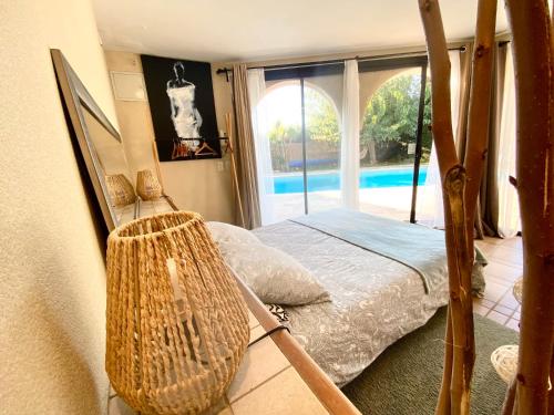 une chambre avec un lit et une vue sur une piscine dans l'établissement Les ormeaux, à Marseille
