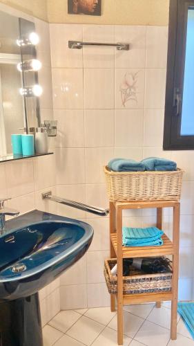 une salle de bain avec un lavabo bleu et un miroir dans l'établissement Les ormeaux, à Marseille
