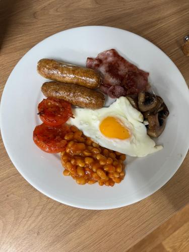 ein Frühstücksteller mit Würstchen, Bohnen und Eiern in der Unterkunft Ford Village Bed & Breakfast in Ford