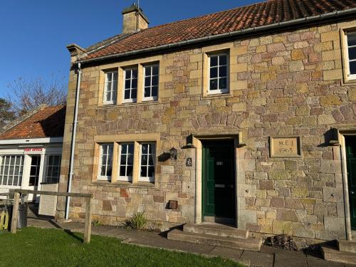 ein altes Backsteingebäude mit einem Schild an der Tür in der Unterkunft Ford Village Bed & Breakfast in Ford