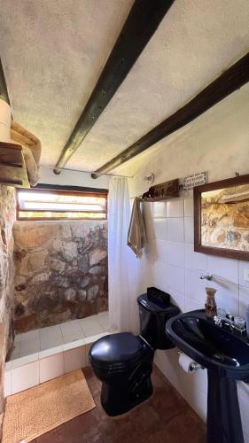 a bathroom with a black toilet and a sink at Hotel, Glampings y Cabaña Magic Bungalow in Villa de Leyva