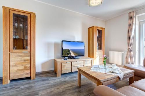 a living room with a flat screen tv on a table at Peenemünde, Seglerhafen ST Tjalk 03 & 10 in Peenemünde