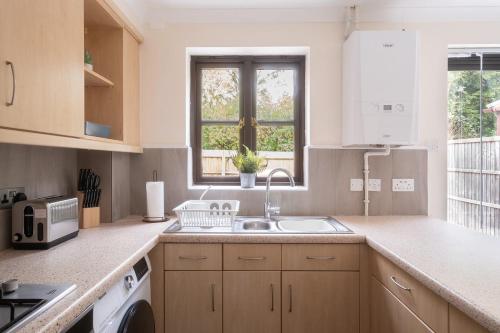 una cocina con fregadero y ventana en Modern and Stylish Home away from Home, en Milton Keynes